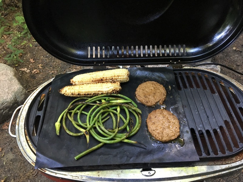 burgers, corn, and garlic scapes on vegan grill mats