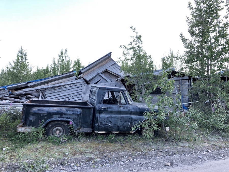 truck in front of fallen building in mccarthy alaska.