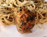 close up of vegan meatball with spaghetti in a red sauce on a plate.