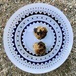 two no bake cranberry energy balls on a plate.