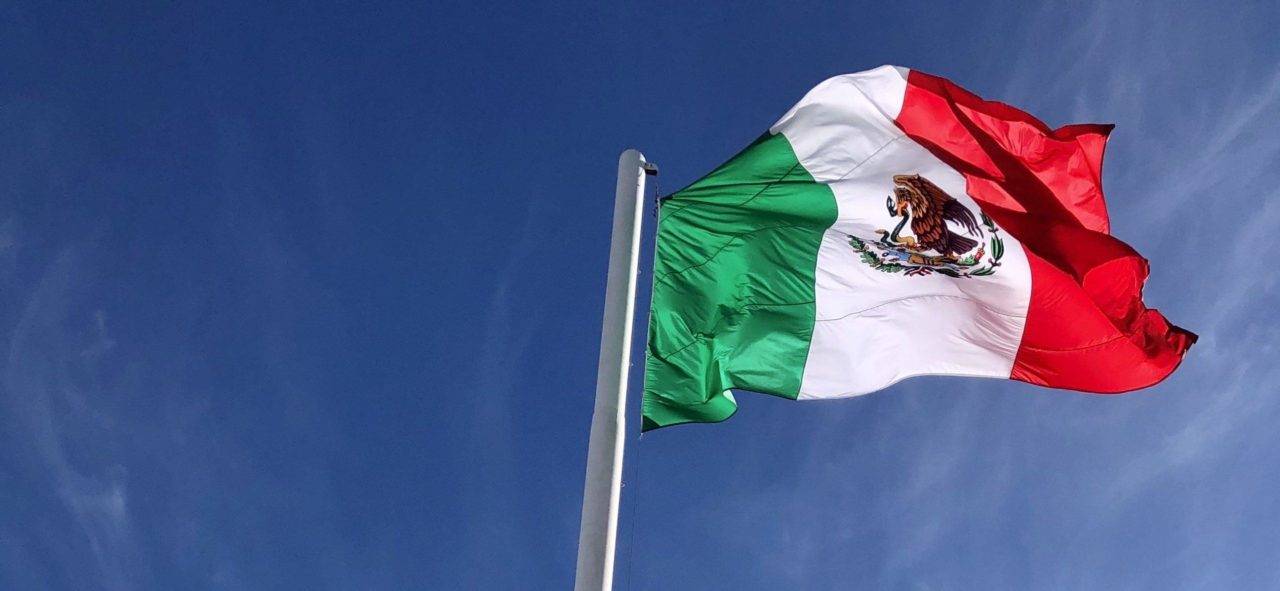 mexican flag against a blue sky.