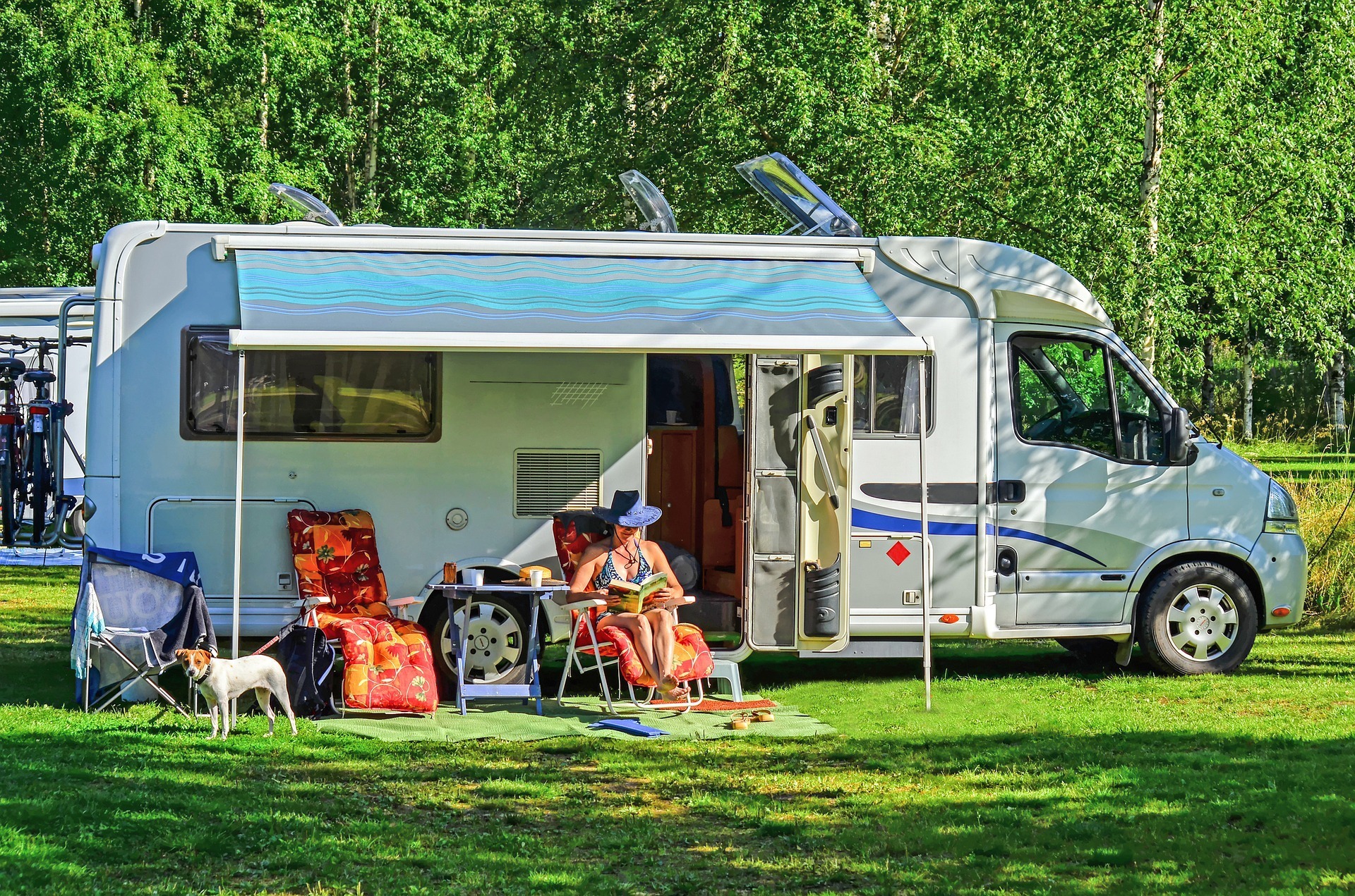 motorhome with awning out and chairs set up outside.
