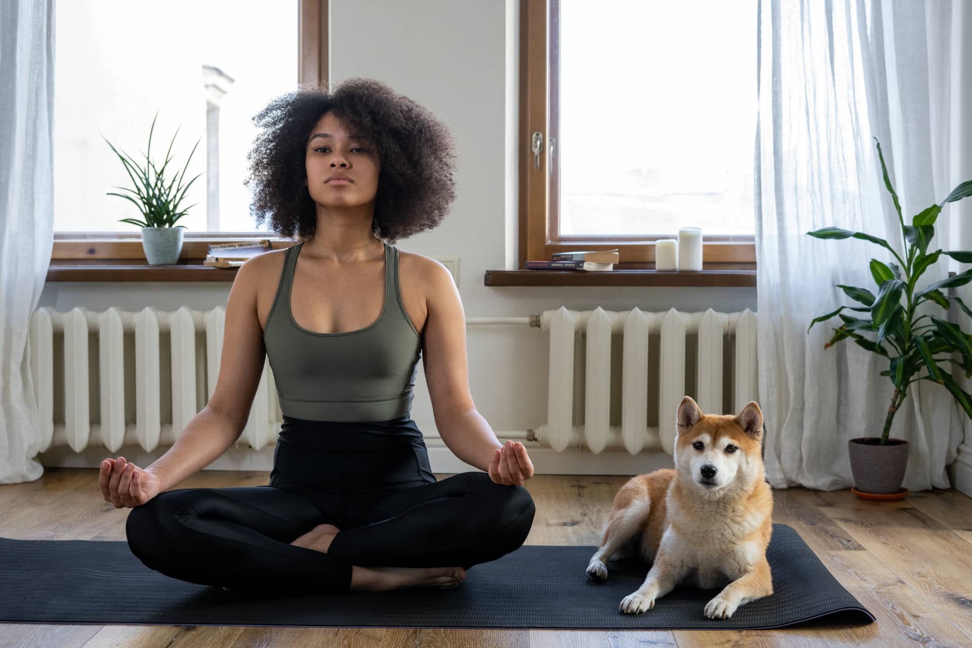woman and a dog on a yoga mat.